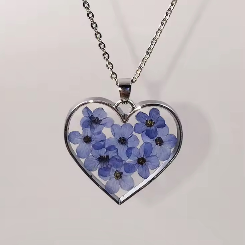 Heart-shaped pendant with natural blue flowers